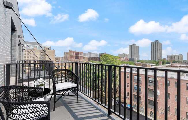 a balcony with two chairs and a view of the city