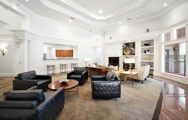 a living room with black leather furniture and a fireplace