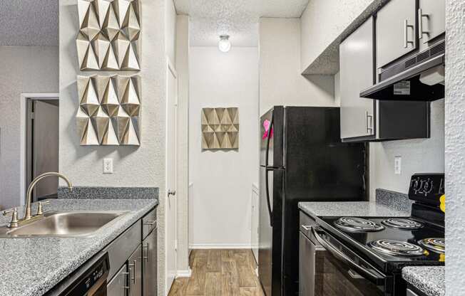 a kitchen with black appliances and granite counter tops