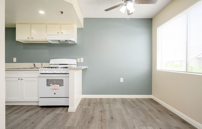 a kitchen with a stove and a ceiling fan at Sagewood Gardens Senior Apartments, Hacienda Heights