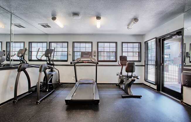 A gym with treadmills, elliptical machines, and a rowing machine.