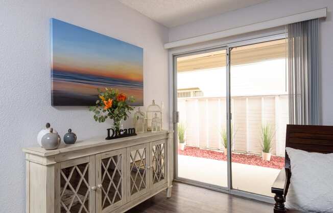 a bedroom with a large painting of a sunset on the wall
