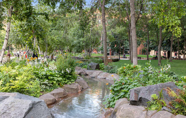 A small stream flows through a rocky area in a park at Lowertown Commons Apartments, St. Paul, MN