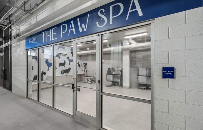 the pav spa entrance with glass doors and a blue sign on the wall