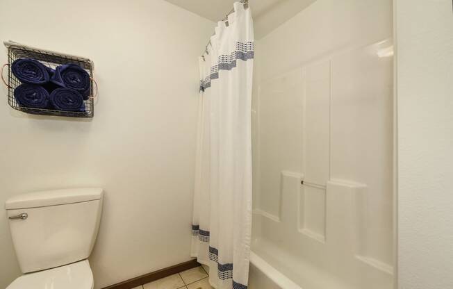 Bathroom with Tiled Floor, Toilet and White Curtains