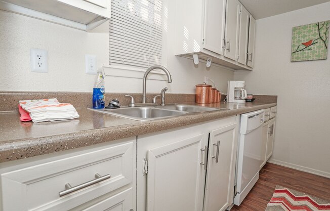 A kitchen with white cabinets and a double basin sink at Laurel Parc apartments in Shreveport, LA.