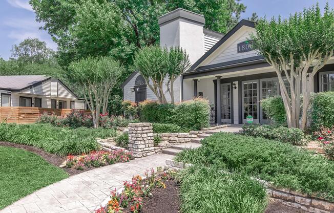 a close up of a flower garden in front of a house