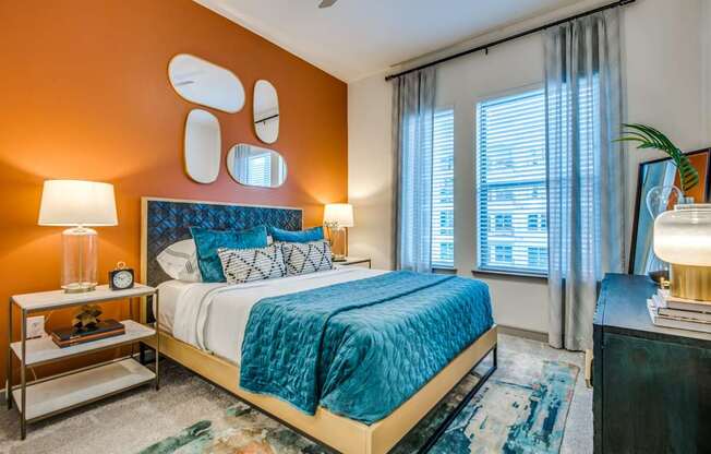 A bedroom with a bed, nightstand, and window.