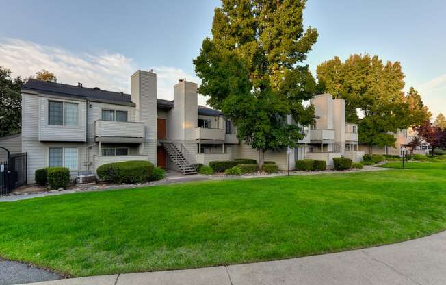 exterior view of apartments with lawns and trees at Cobblestone Creek Apartments