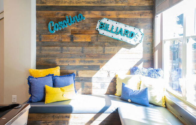 a seating area with pillows and a reclaimed wood wall