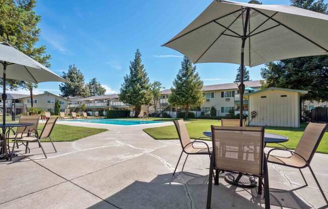 Gilroy Apartments for Rent - Mission Park - Outdoor Lounge Area With Seating, Tables, and Umbrellas Near the Swimming Pool