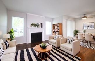a living room with white furniture and a fireplace