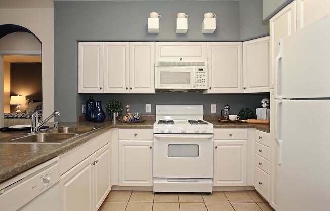 A kitchen with white appliances and cabinets at The Kitt at Warner Center Apartments, Woodland Hills 91303