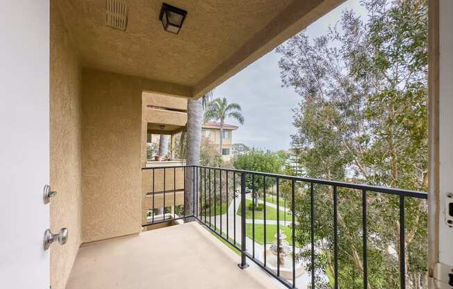 the balcony has a view of the backyard and the trees at Huntington Terrace North Senior, California