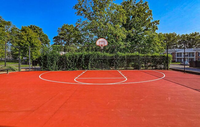 a red basketball court with a basketball hoop on it