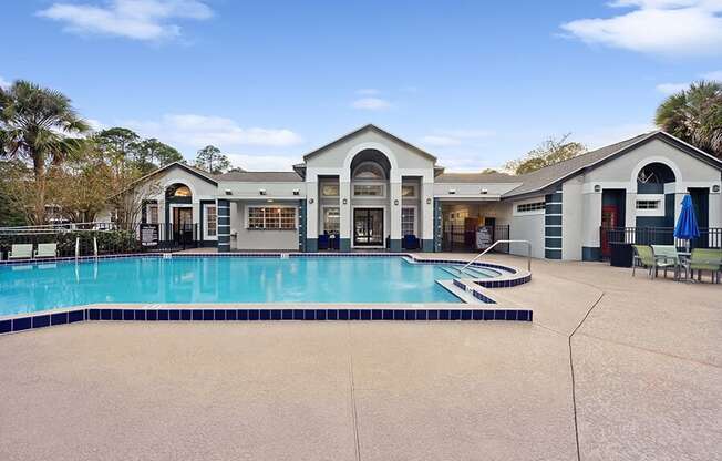 Community Swimming Pool with Pool Furniture at Vue at Baymeadows Apartments in Jacksonville, FL.