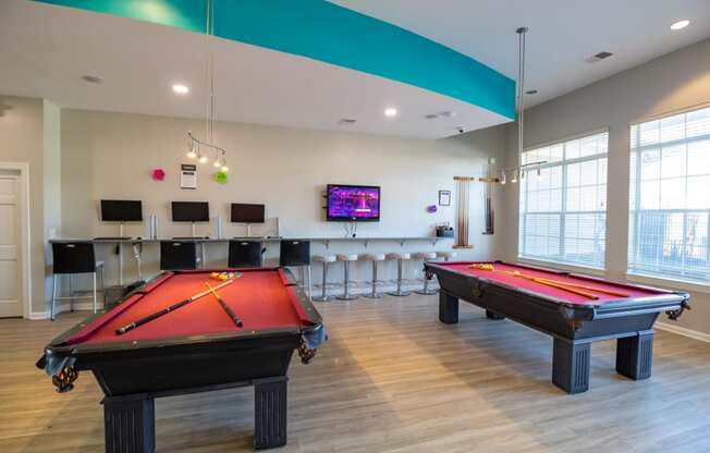 a games room with two pool tables and a tv