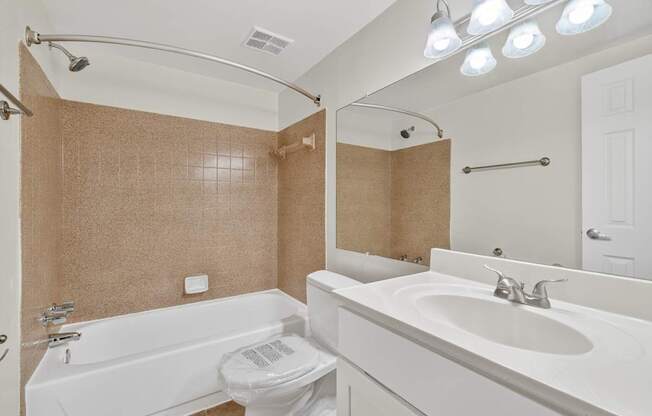A white bathroom with a toilet, sink, and bathtub.