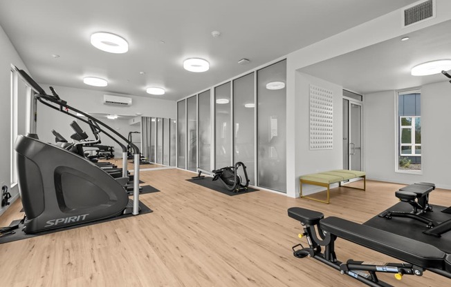 a gym with treadmills and other exercise equipment on a wood floor