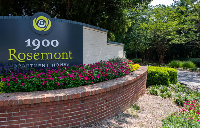 a brick retaining wall with a sign for rosenmont apartment homes