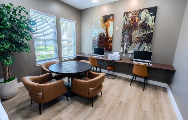 a conference room with two computers and chairs and a table