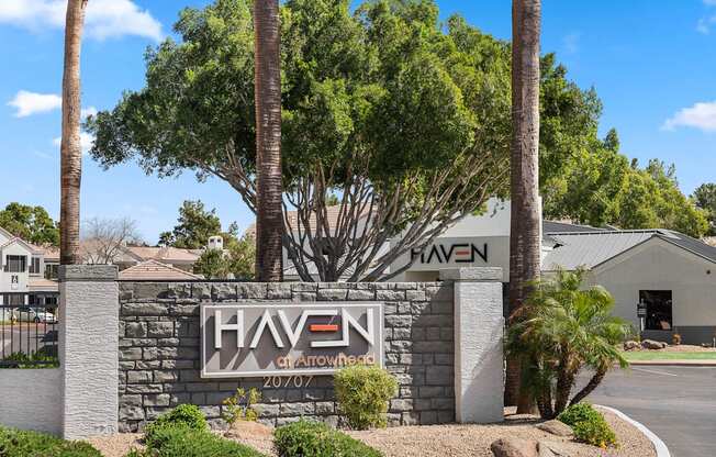 A sign for Haven at Arrowhead with a tree in front.