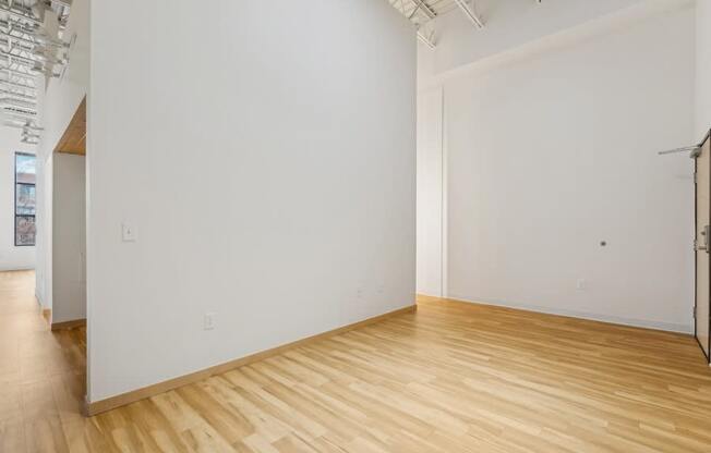 A room with wooden flooring and white walls.