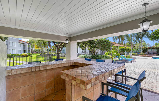 A patio with a table and chairs under a roof.