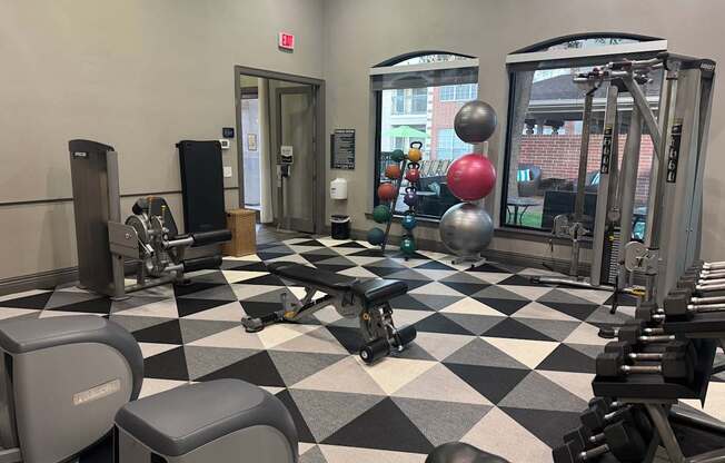 A gym with a variety of equipment including weights and a bench press.