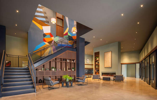 the lobby of a hotel with stairs and a colorful stairwell