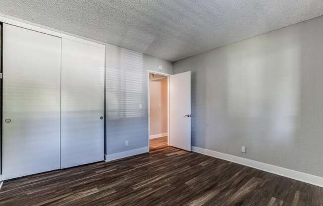 a bedroom with white cabinets and a door to a closet at Aspire Upland Apartments, Upland, CA