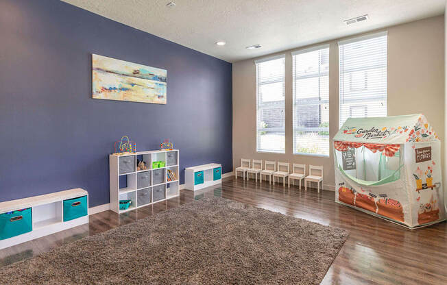 a playroom with a play table and chairs and a large window