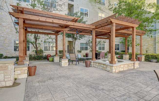 a patio with a pergola and a table and chairs