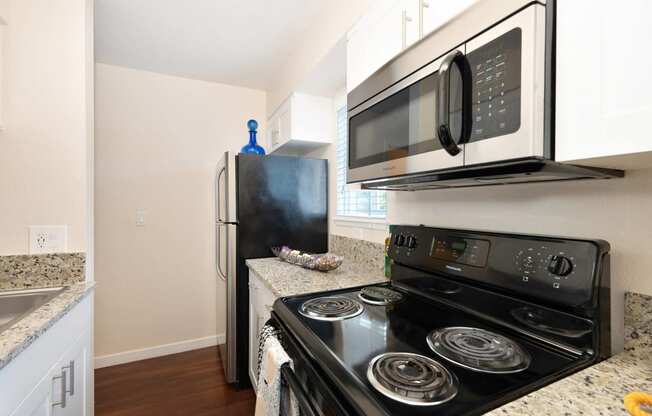 a kitchen with a stove and microwave and a refrigerator