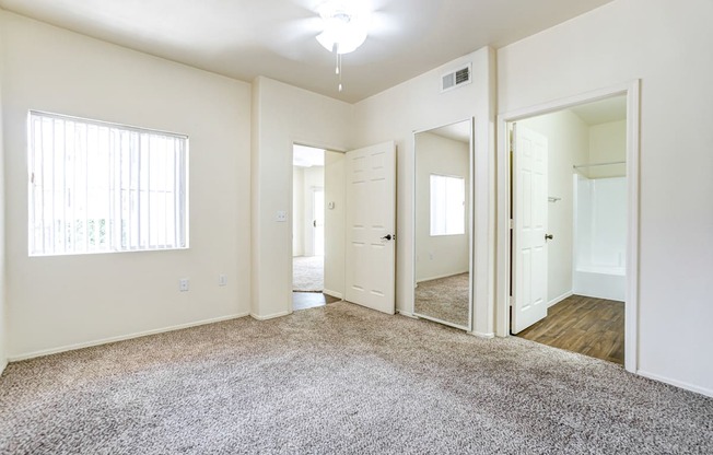 A spacious room with a carpeted floor and white walls.
