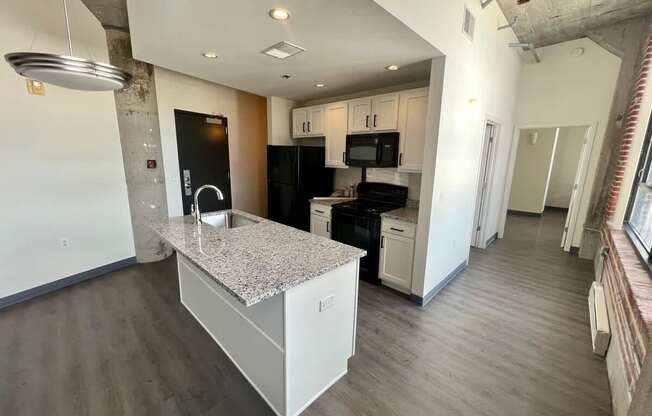 A kitchen with a granite countertop and stainless steel appliances.