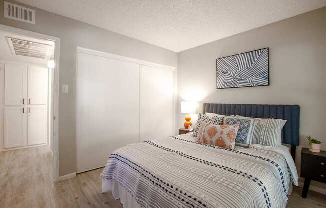 A bedroom with a large bed and a painting on the wall.
