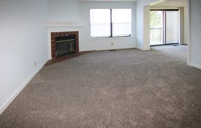 A room with a fireplace and carpeted floor.