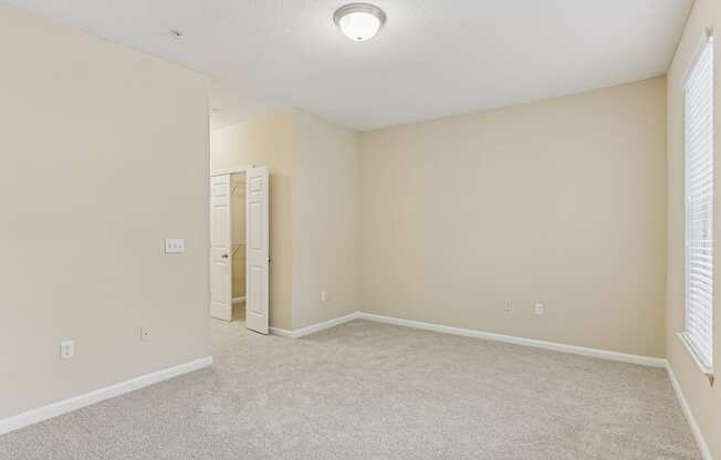 A room with a carpeted floor and a white ceiling light.