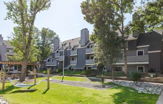 a view of an apartment community with hammocks and trees