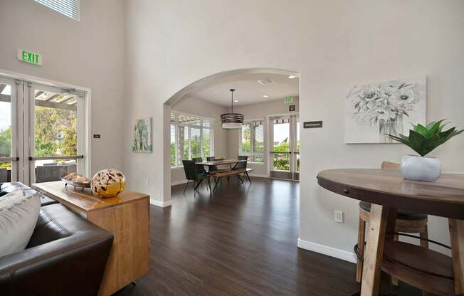 A living room with a brown leather couch and a wooden table.