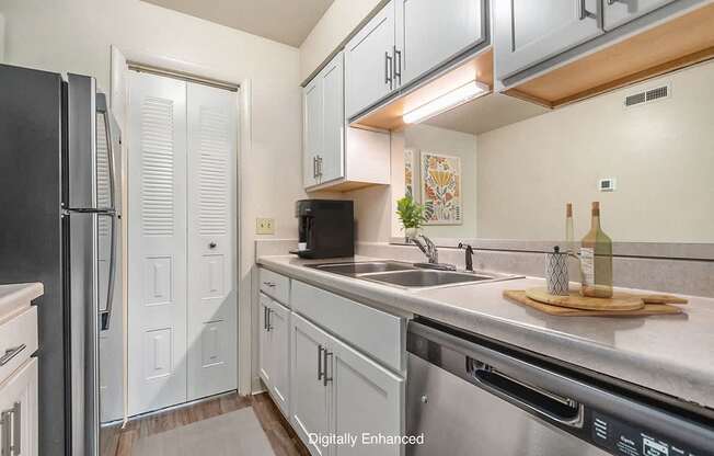 A kitchen with white cabinets and a black refrigerator.