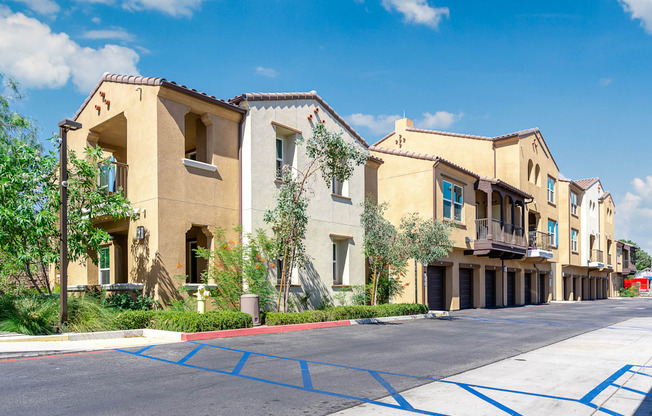 a row of apartment buildings with blue parking mats in front of them