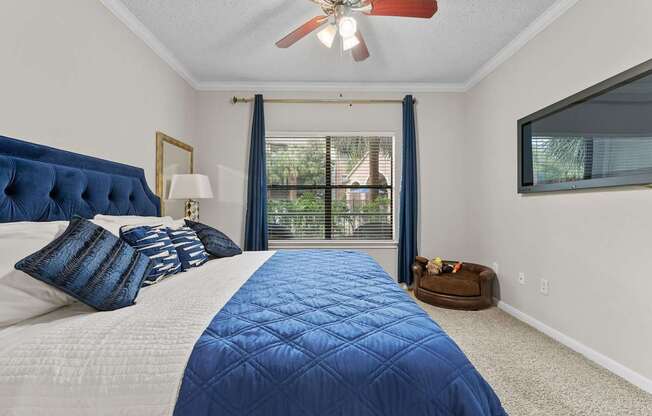 A bedroom with a large bed and a ceiling fan.