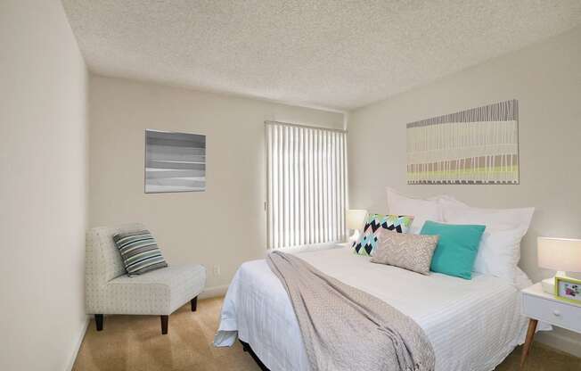 Bedroom with carpet flooring, vertical blinds. Not all features are available in every apartment.