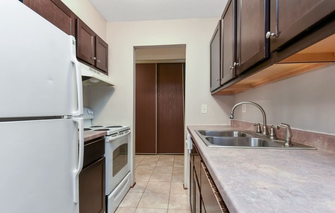 a kitchen with a sink and a refrigerator and a stove. Roseville, MN Rosedale Estates