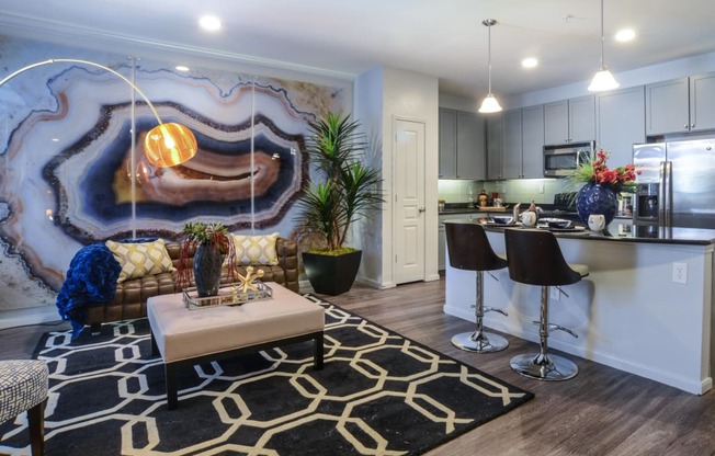 a living room with a kitchen and a rug