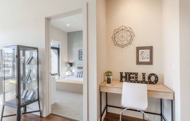 a home office with a desk and a doorway to a bedroom