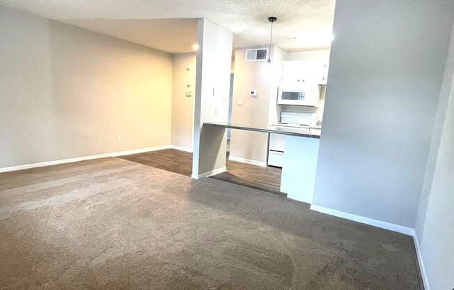 A carpeted room with a doorway leading to another room.