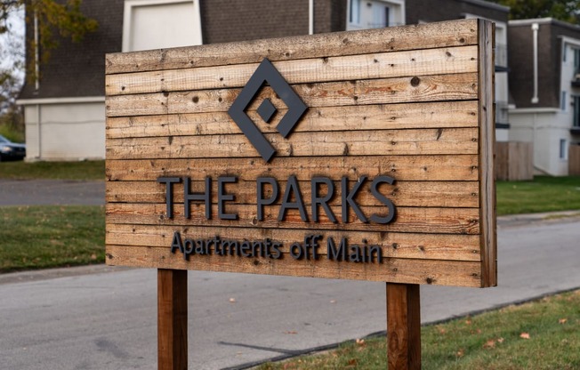 a sign that reads the parks apartments off main in front of a street
